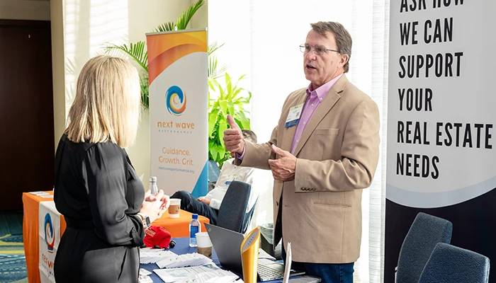 Two business people chatting in front of trade show banners